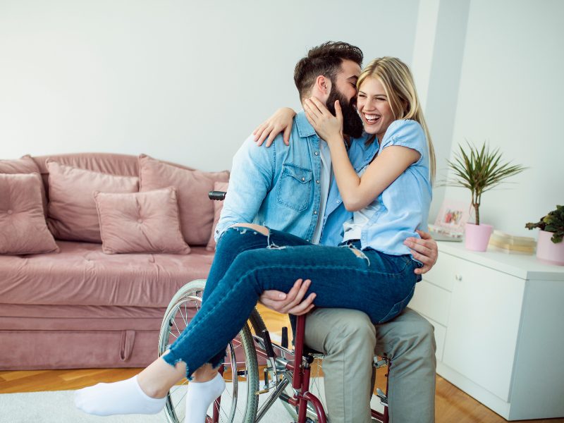 A couple sitting together on a sofa, talking and laughing